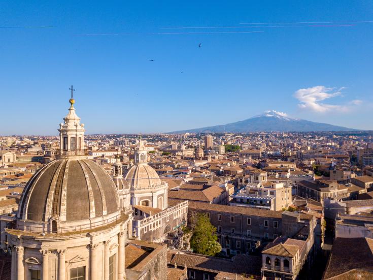Aerial view of the Cathedral of Sant'Agata in the middle of Catania with Etna volcano on the background