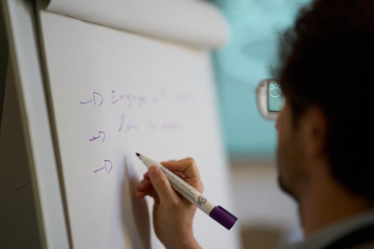 Person writing on white board