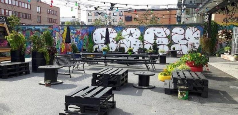 Urban Garden in Pori, made with well-being money Benches and city green with a background graffiti