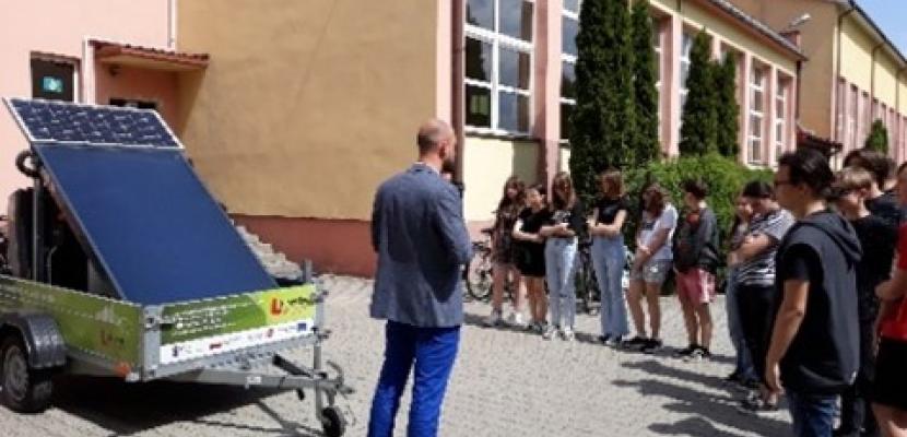 Educational campaign at school The picture shows children standing in front of the school where the photovoltaic panel is presented