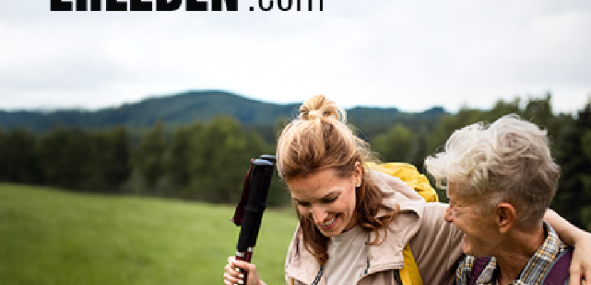 GemeinsamErleben An adult woman and an elderly woman in an outdoor space holding walking poles.