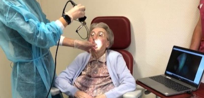 A nurse takes a video of the older person's oral cavity