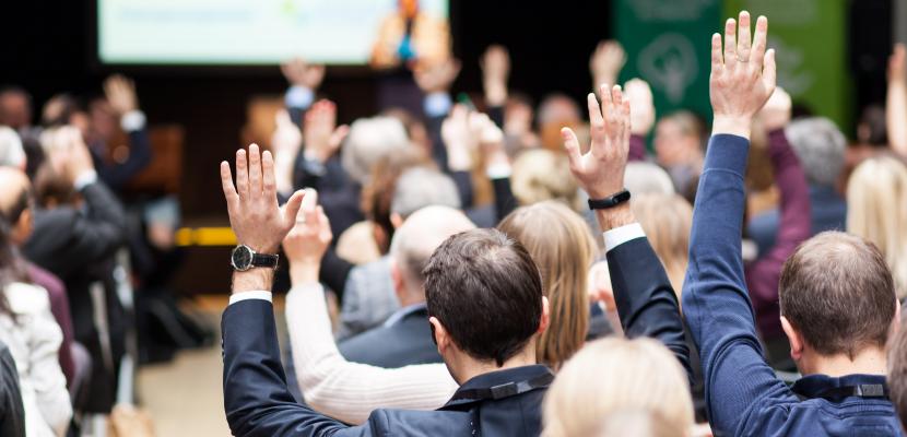 Participants of an event raising hands Participants of an event raising hands during a plenary