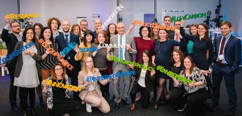 Joint secretariat staff posing for team photo holding wooden hashtags