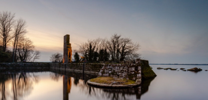 Ruins by the Water: A Lough Derg Sunset Historic stone ruins on the edge of Lough Derg, reflected in still waters at dusk.