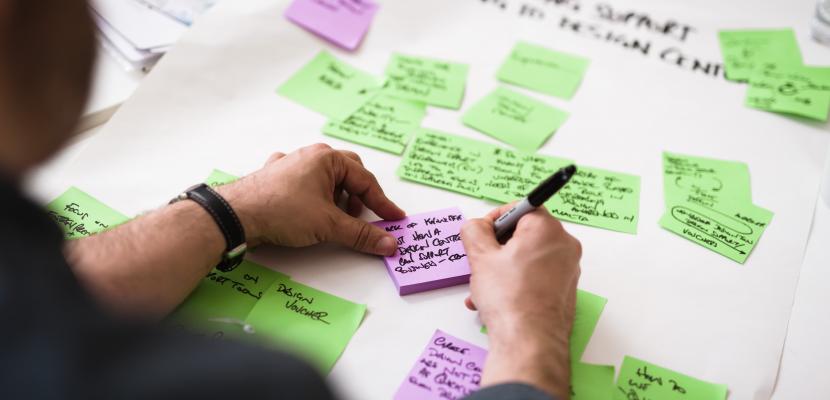 Person writing on post it Person writing on post it