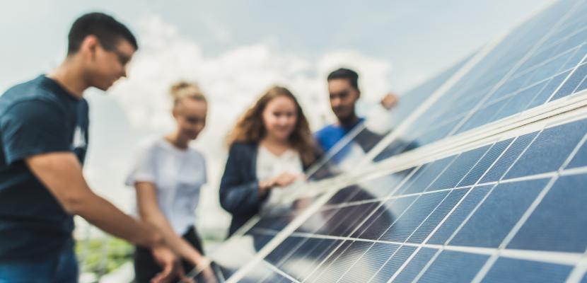 Group of people around a solar panel Group of people around a solar panel