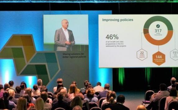 Man doing powerpoint presentation in front of an audience. 