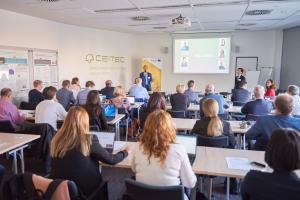 People from behind sitting and listening to a presentation