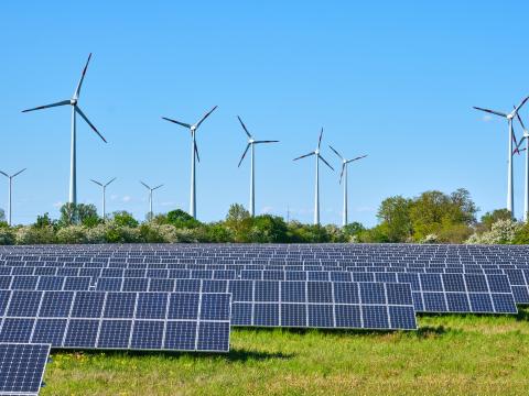 Windmills and solar panels in field Windmills and solar panels in field