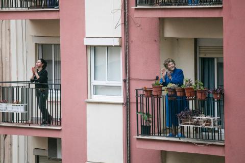 Two women applauding on their balcony