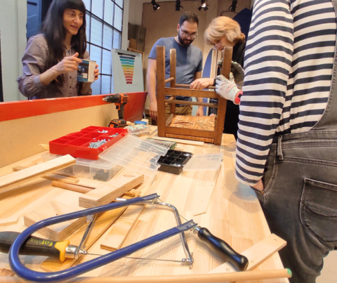 Hands on furniture repair workshop with participants restoring a wooden chair in Kyklos Lab
