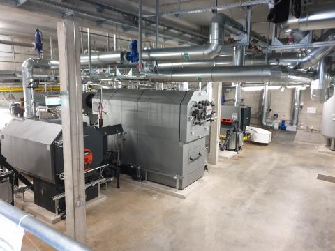 In the central heating plant, two pellet boilers generate the of the heat is generated in two pellet boilers. At peak load times or when other other systems fail, additional heat is additional heat is produced from bio natural is produced.