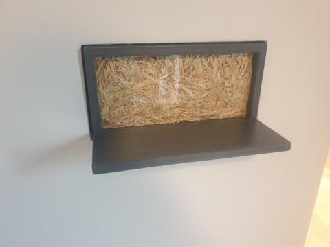 Viewing window in the guest house with straw filling in the wall