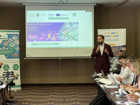 A man in front of an audience welcoming the attendees