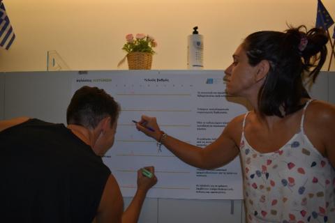 Attica Stakeholder meeting 1 two persons writing on a poster on the wall
