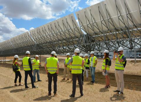 Group of people in high visibility protection clothing visits solar panel installation