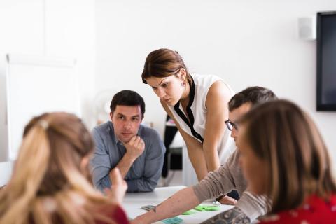 Four people at a table discussing and working Four people at a table discussing and working