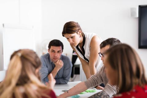 Four people at a table discussing and working