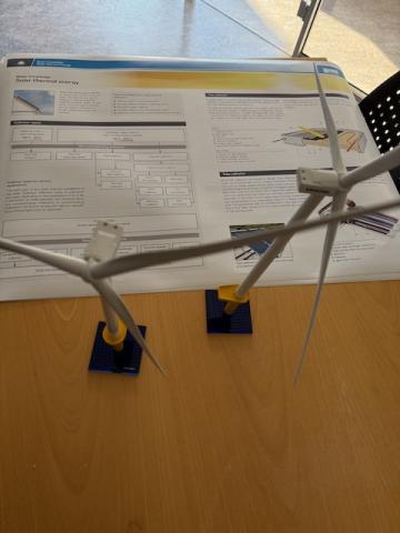 small windmills on a table, with fact sheet about solar power