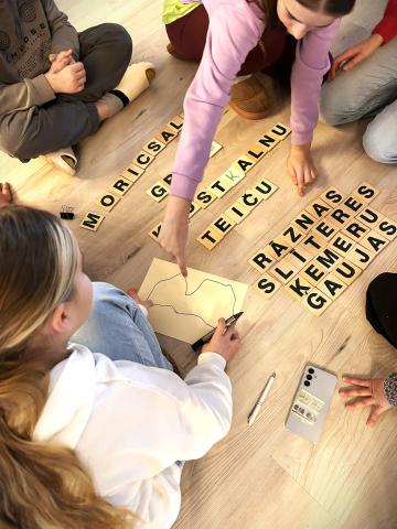 I see some children playing with pieces that represent letters