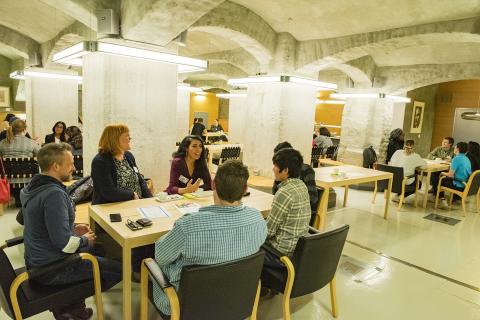 Juttuklubi members sitting around a table and discussing