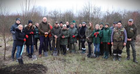 Participants in local communication action. Group picture of 20 people standing to the camera with winter clothes on and shovels in hand in Nida River Delta.