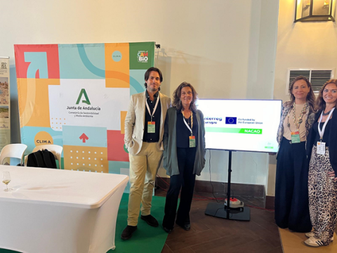 Nacao´s Andalusian team in CLIMA A man and a woman standing in a conference room, facing the photographer, while two women stand to the side, also looking at the camera.