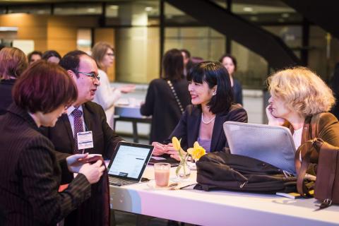 People speaking around a table at an event People speaking around a table at an event