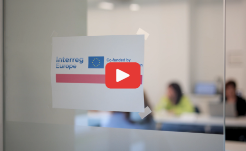 Aftermovie 4th partner meeting and study visit Paper with NEAR logo attached to glass door with play button