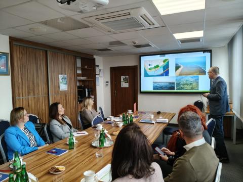 Stakeholders in Poland. People in the meeting room watchin ppt presentation.