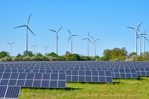 Windmills and solar panels in field Windmills and solar panels in field