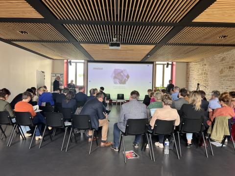 AI Seminar in Never with Nievre Numerique Audience seated at an event with a presentation screen displaying "ENAIBLER" and a speaker at the podium.