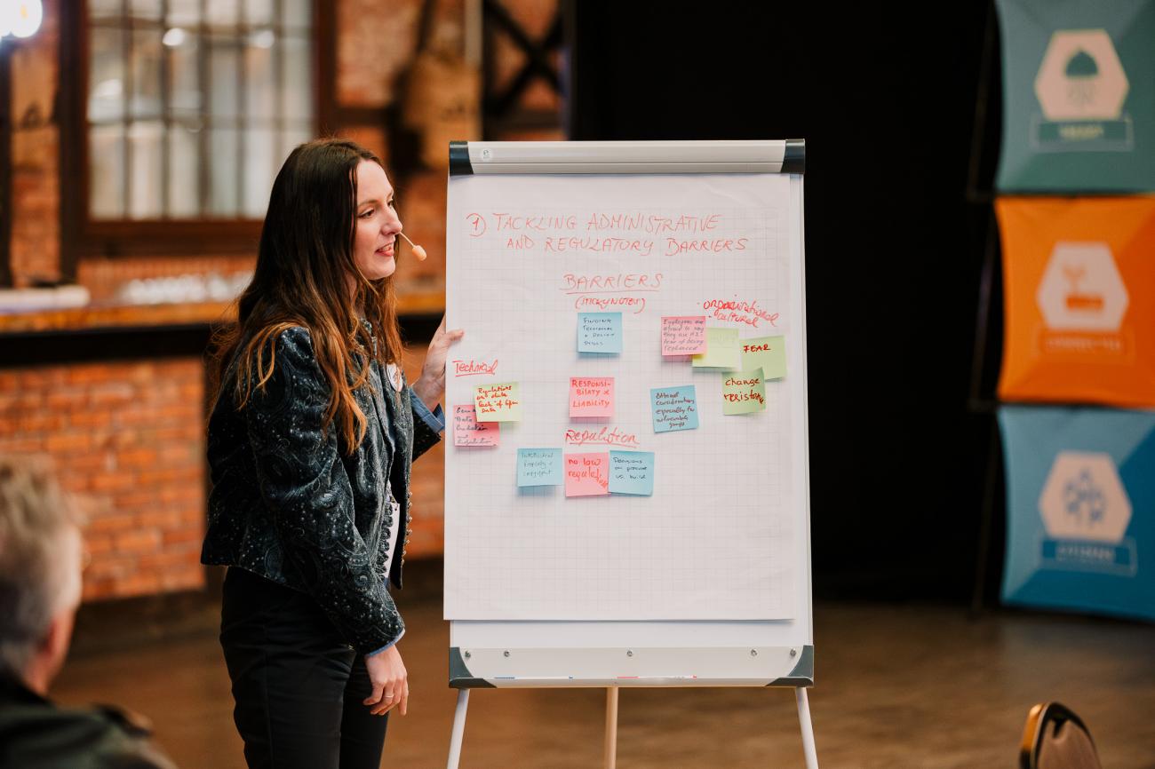 Woman standing next to flipchart discussing with group at Europe, let's cooperate 2025 in Krakow