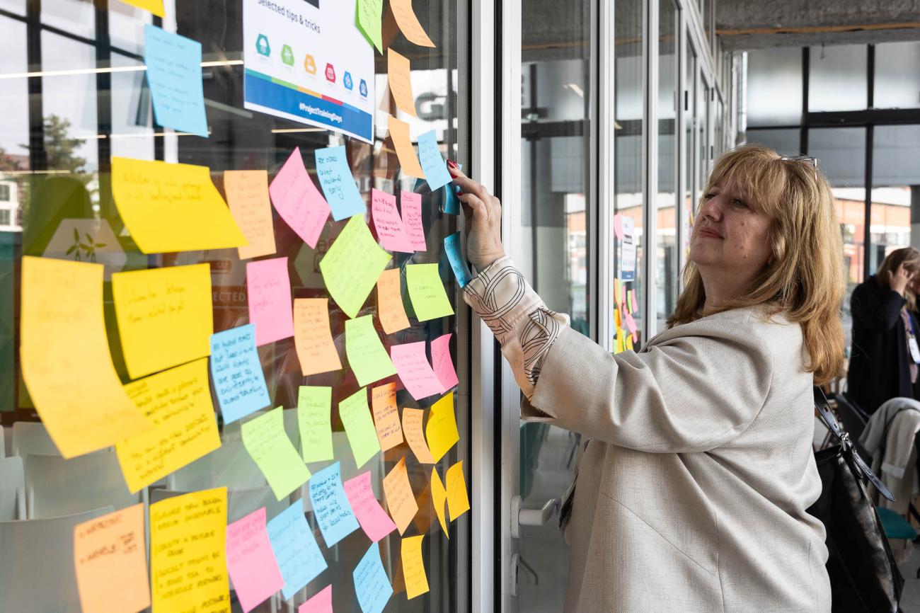 event participant putting post-it note on a wall