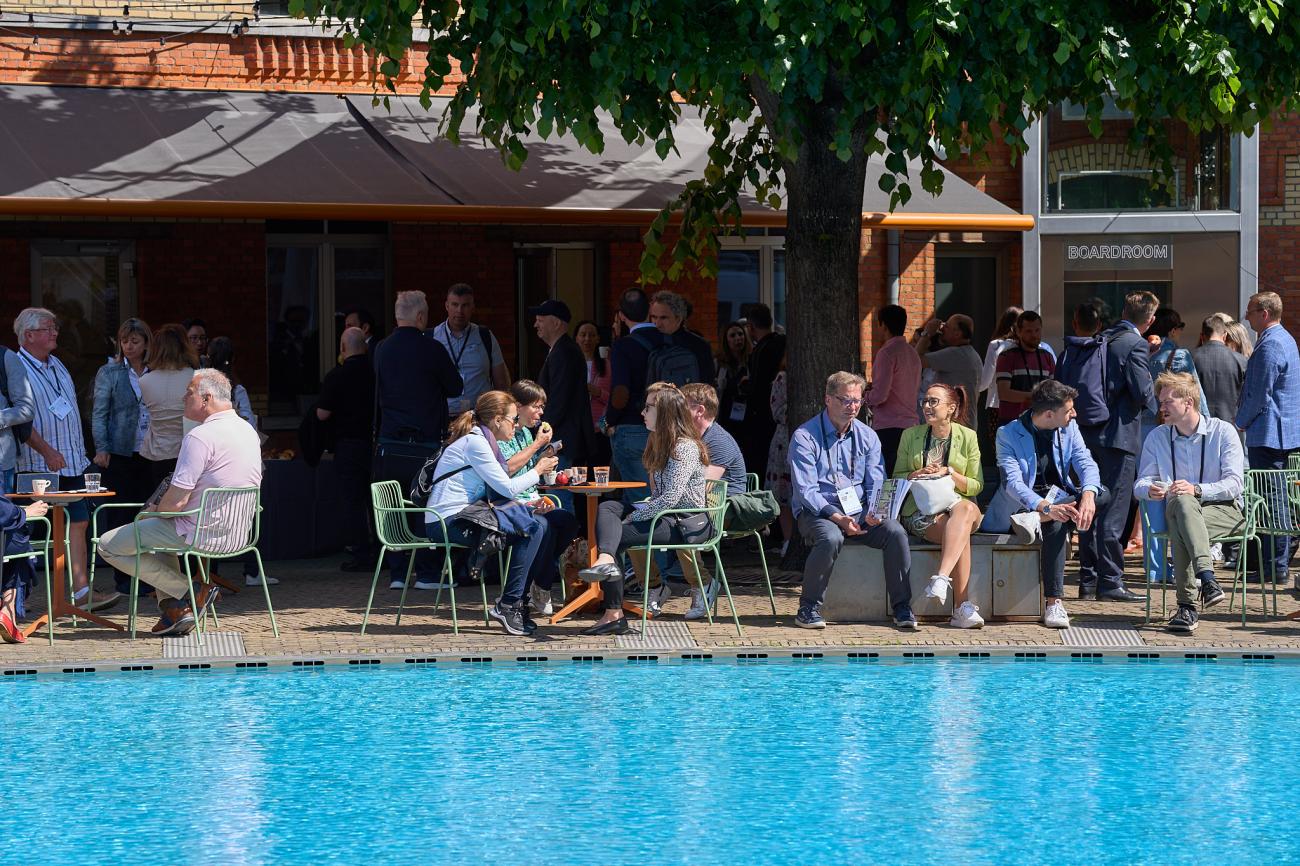 People sitting down in front of pond