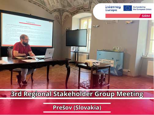3rd Regional Stakeholder Group Meeting – Prešov (Slovakia) Person sitting at a table with a laptop, behind him a screen on which a presentation is played