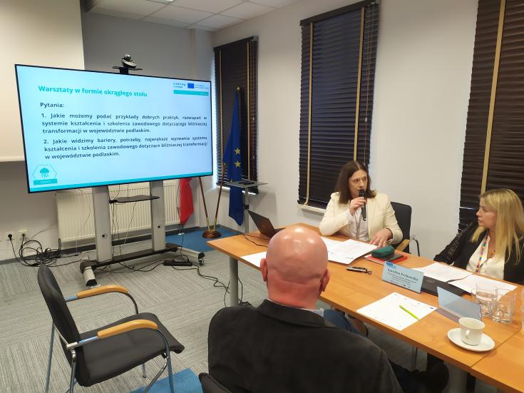 Stakeholder Group Podlaskie 3 people sit in a room and look at a powerpoint