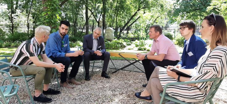 six people talking in a garden 