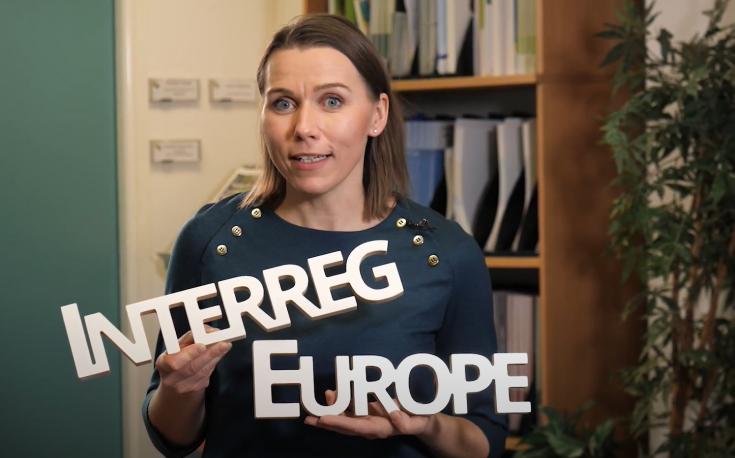 Person holding signs with words Interreg and Europe