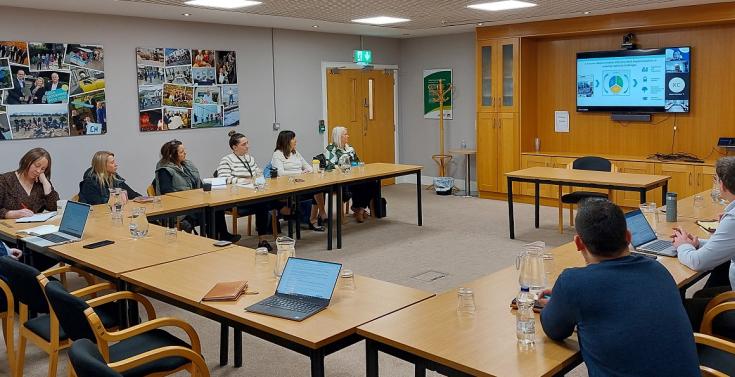 People sitting in a meeting room, watching a presentation