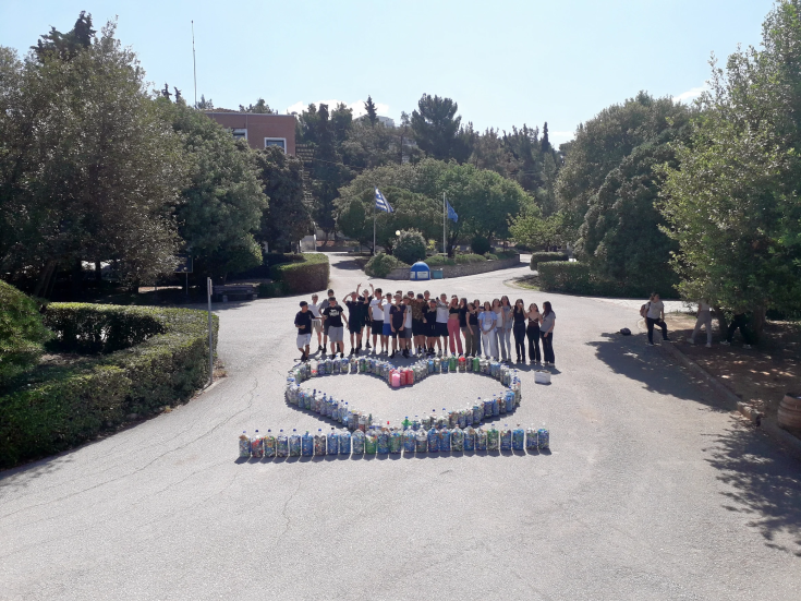 A group of students posing with the collection of plastic caps they have carried out