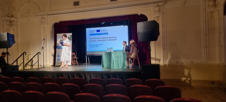 Photo from a dissemination event in Nowy Dwór Mazowiecki - shows the stage and speakers.