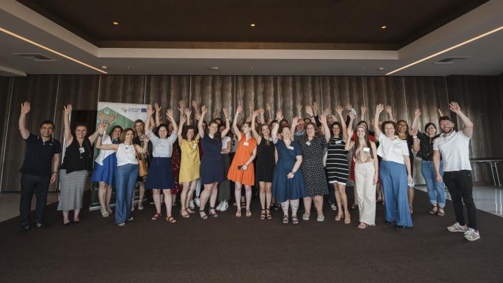 Group of people standing before a wall and raising theirs hands Group of people standing before a wall and raising theirs hands