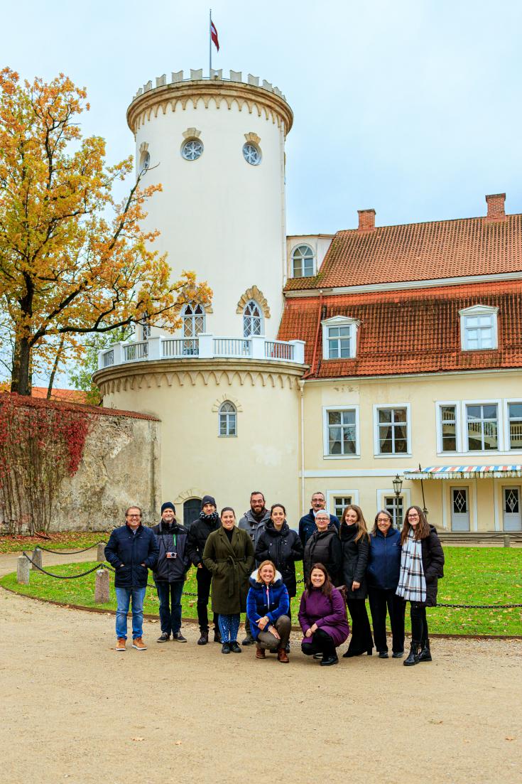 Group of people posing in front of a castle, in Cēsis, Latvia. 