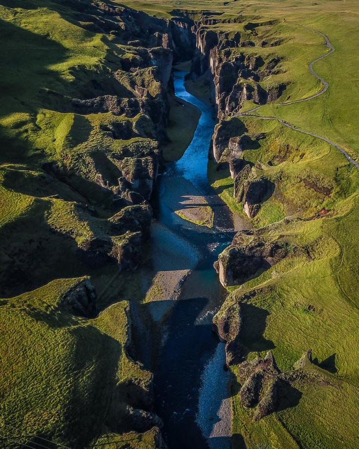 Bird view of river running through green mountains