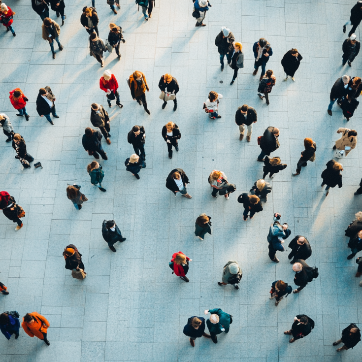 Looking down from above, we see people in a big waiting lounge - all standing up or walking.