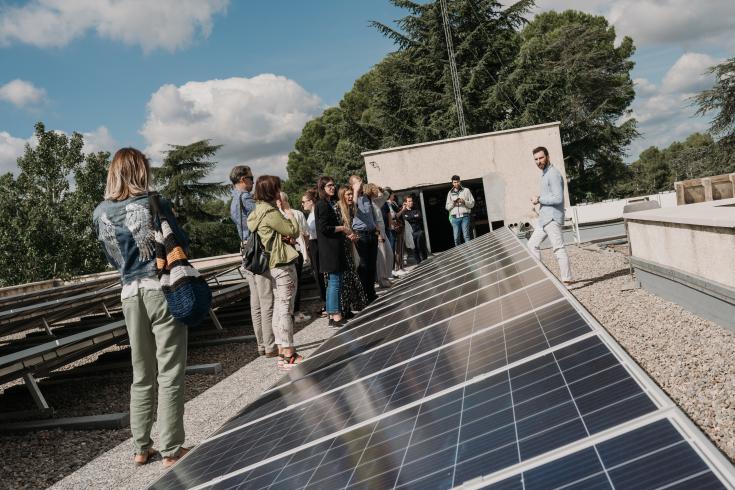 Group of people standing in front of solar panels Group of people standing in front of solar panels