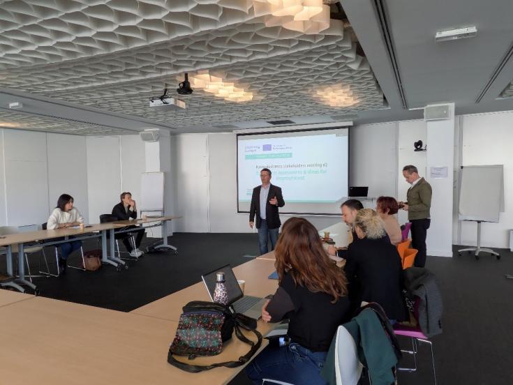 people gathered  in a room, looking at presentation