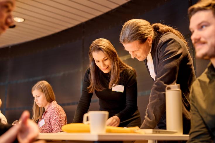 Participants to Helsinki workshop People looking at something on a table